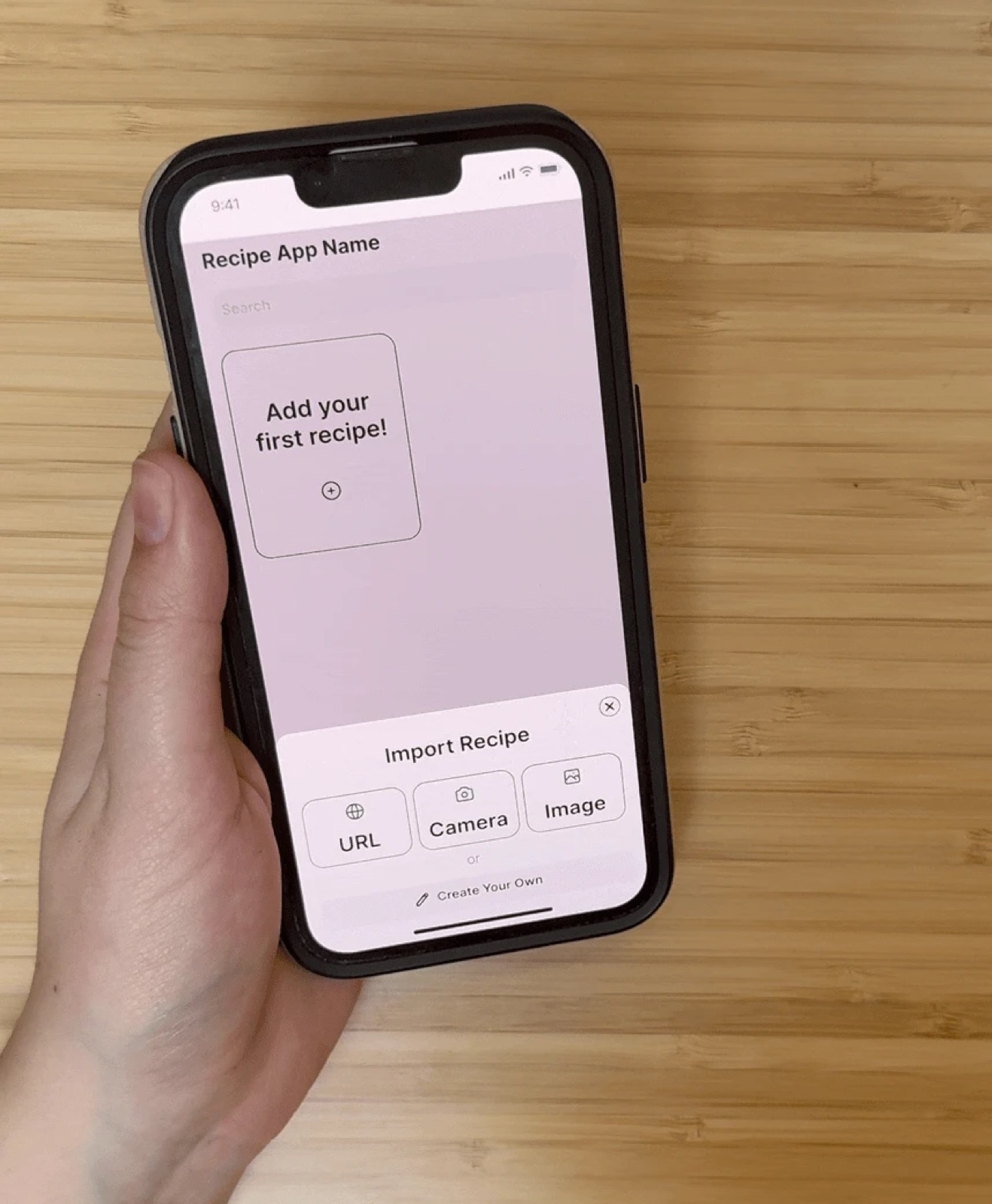 A usability testing participant holding a phone showing the mid-fidelity Import Recipe screen