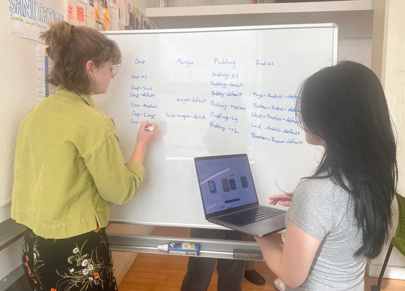 Claire and a teammate defining gap, margin, padding, and radius tokens on a whiteboard.